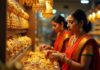 Indian women buy golden ornaments in a big shop.